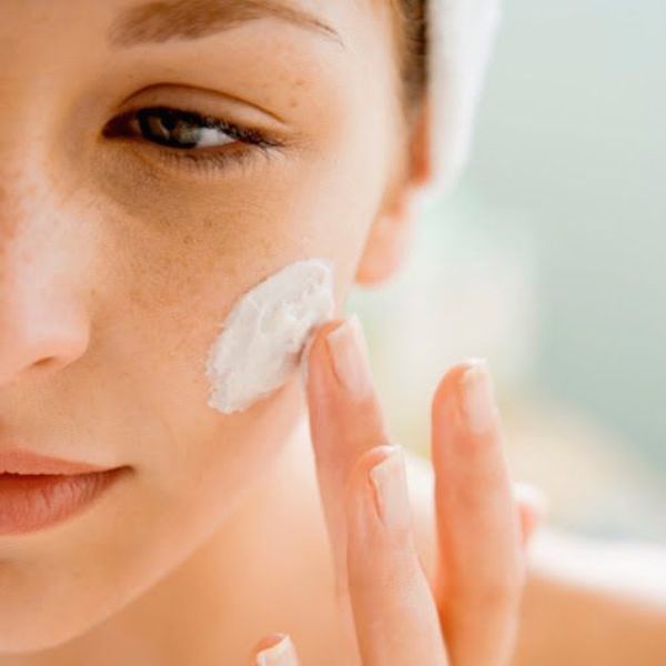 woman putting cream on face